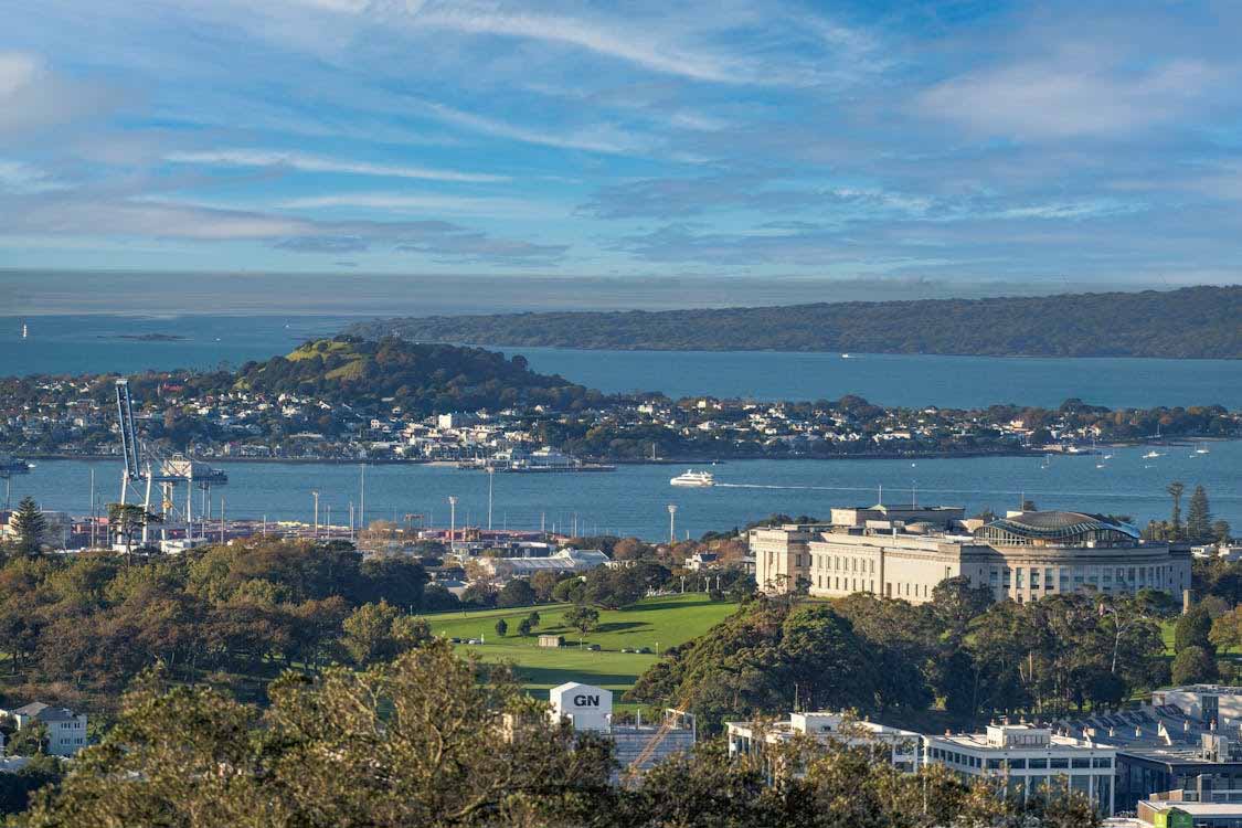 Auckland harbour view with coastal homes and buildings near the water, showcasing typical seaside roofing exposure.