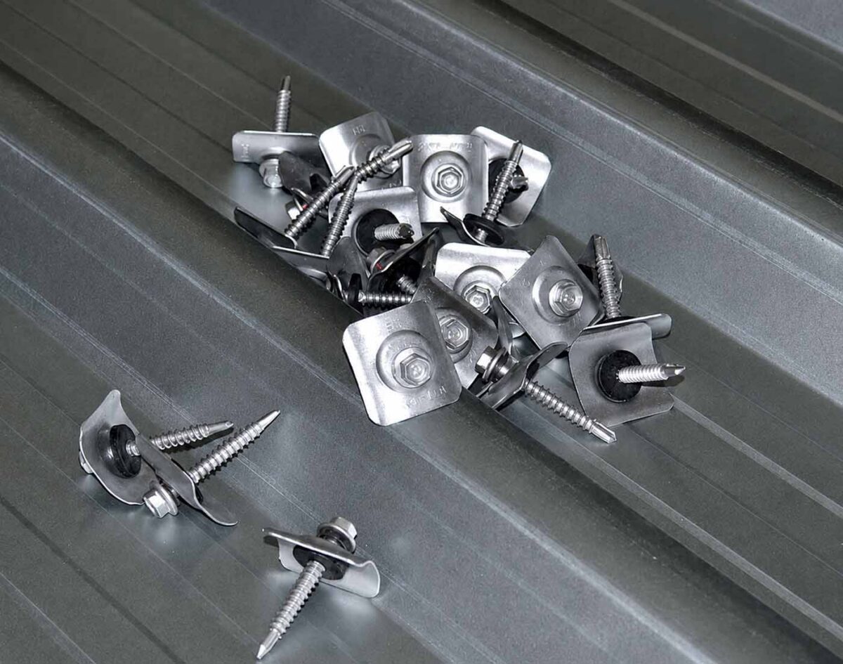 Roofing fasteners and washers placed on long run metal roofing sheet before installation